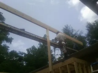 Carpenter setting a ridge beam over a new addition frame — Ice Dam Removal by Roofing Brothers in Porum