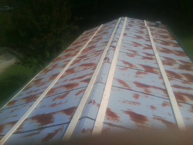 Rusted metal roof panels with new wood purlins before replacement — Storm Damage Roof Repair in Porum by Roofing Brothers