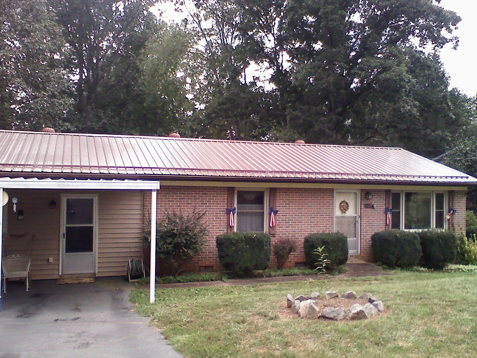 Bronze metal roof and carport on a brick ranch home — Roof Repair work by our crew in Porum