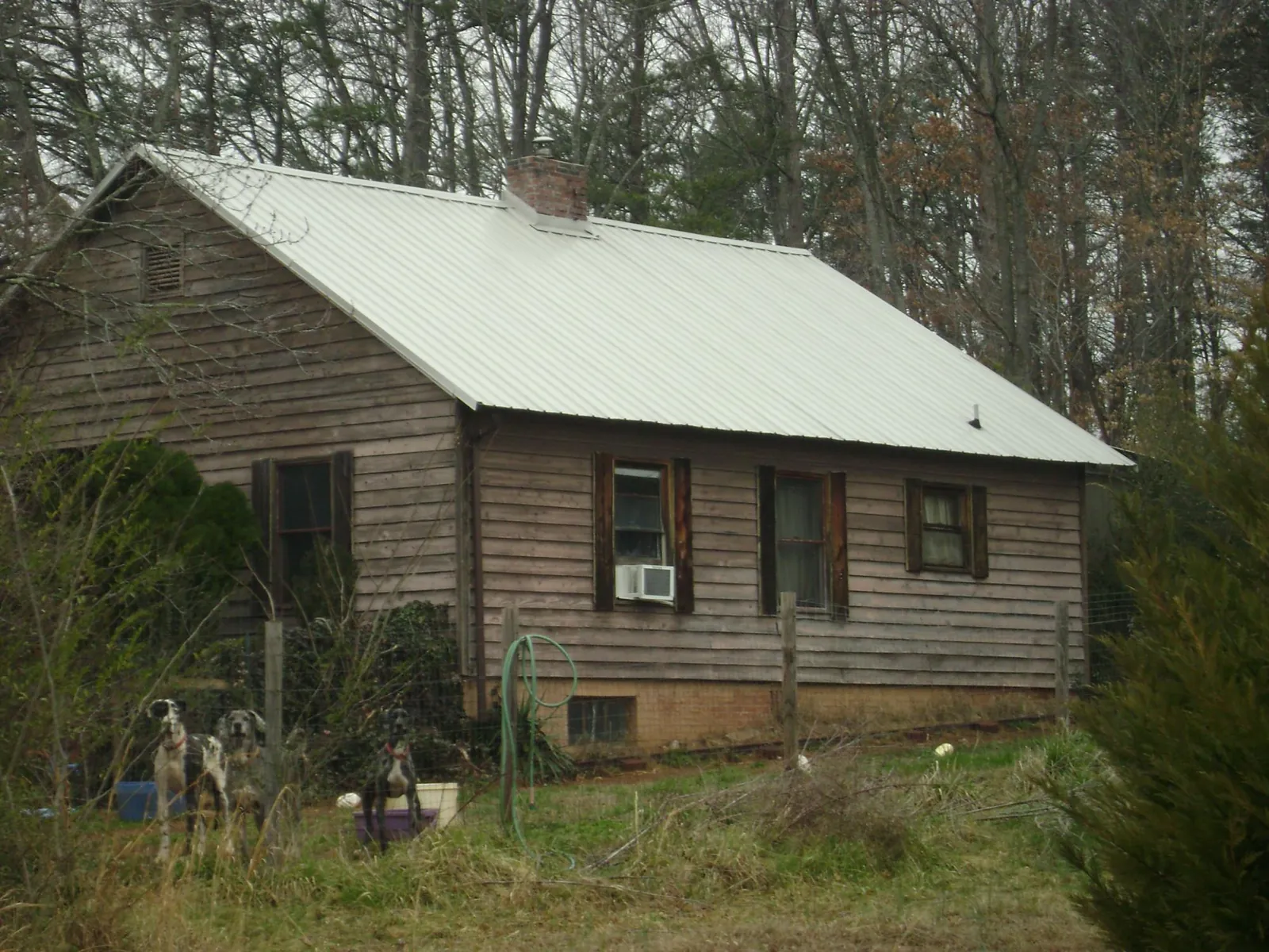 White metal roof on an old wood sided farmhouse, from a Metal Roof Installation job in Porum